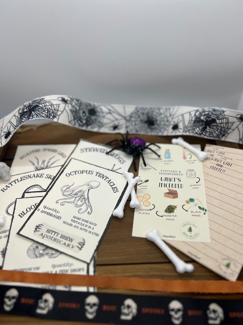 K&ouml;nnte beinhalten: Ein Halloween-Bastelset mit verschiedenen Materialien. Das Set enth&auml;lt bedruckte Karten mit gruseligen Illustrationen, k&uuml;nstliche Knochen, eine schwarze Spinne und dekoratives Band mit Spinnweben und Totenk&ouml;pfen. Das Set ist zum Basteln gedacht.