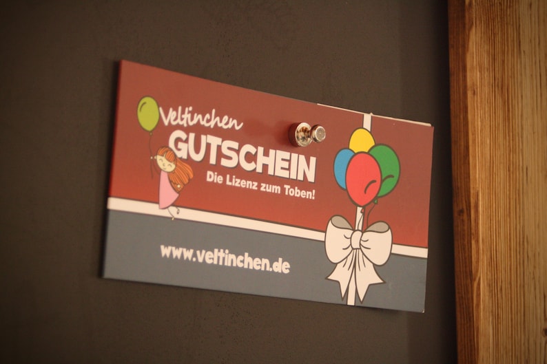 May include: A red and gray gift certificate with the text "Veltinchen Gutschein" and "Die Lizenz zum Toben!"  The certificate features a cartoon girl holding a balloon and a bow with balloons.