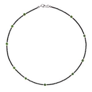 May include: A black beaded necklace with green gemstone accents.