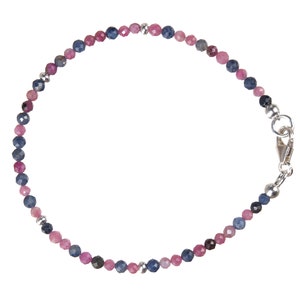 Op de afbeelding: Een delicate armband gemaakt met afwisselende roze en blauwe edelsteen kralen en zilveren accenten. De armband heeft een zilveren sluiting.