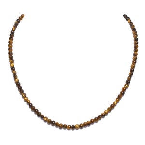 Puede incluir: Un collar de cuentas de ojo de tigre dorado y marrón. El collar está hecho de pequeñas cuentas redondas y tiene aproximadamente 45 cm de largo.