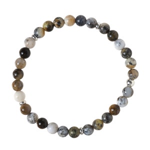 Pode incluir: Um bracelete feito de contas de pedras preciosas marrons, cinzas e brancas com detalhes prateados.