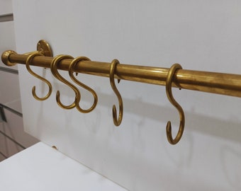Rustic unlacquered brass pot rail with a 16 mm rod and S-hooks for pots, pans, and more