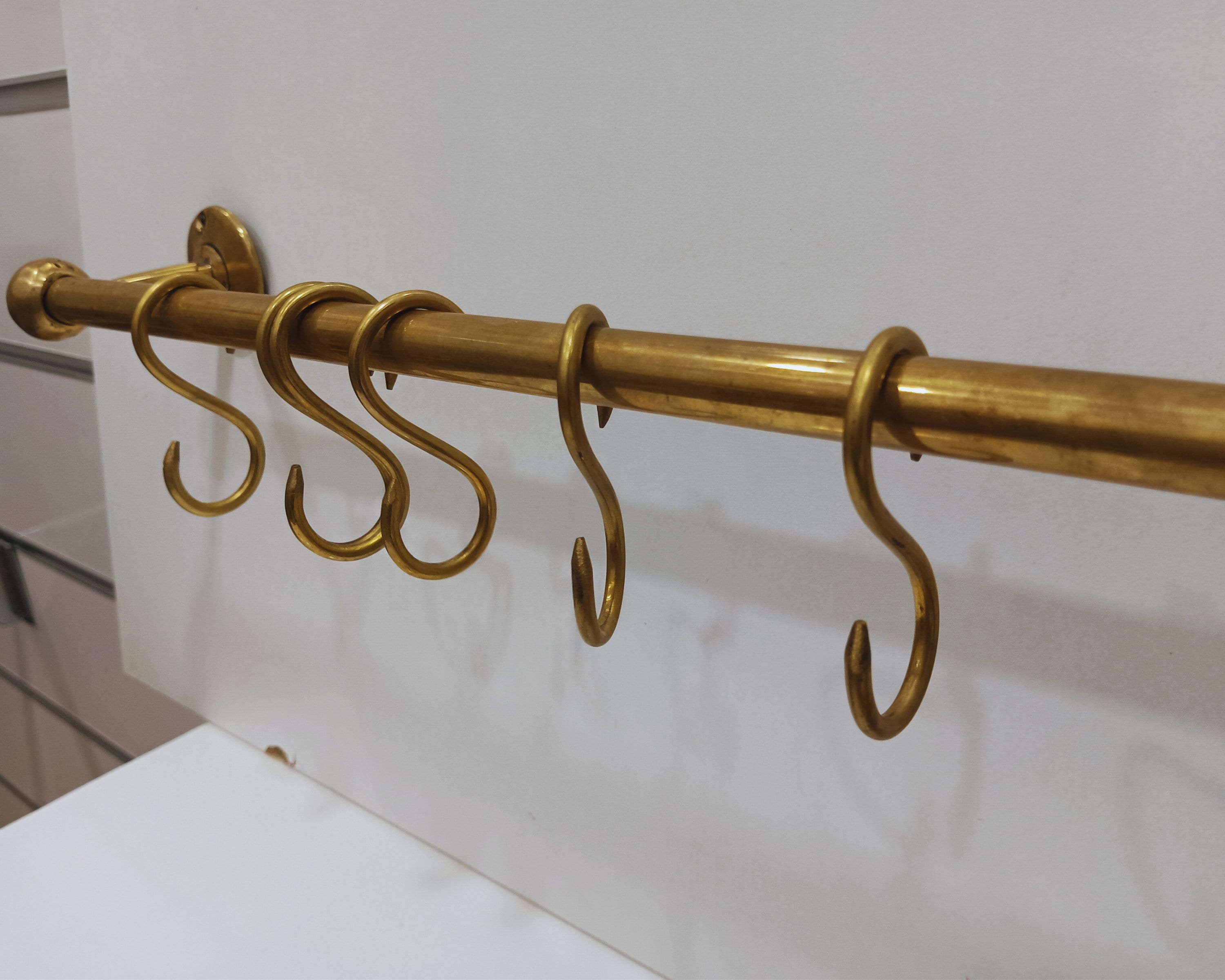 Rustic unlacquered brass pot rail with a 16 mm rod and S-hooks for pots, pans, and more