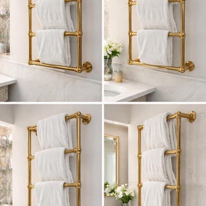 May include: A gold-colored towel rack with three horizontal bars, holding folded white towels. The rack is mounted on a white wall, suggesting a bathroom setting. The design is classic and elegant.