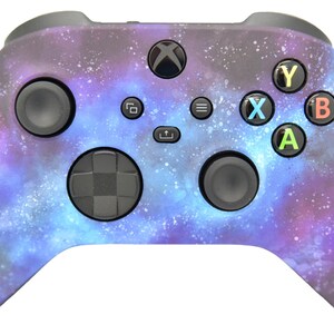 May include: A purple and blue galaxy-themed Xbox controller with black buttons and a black d-pad.