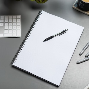 May include: A white spiral bound notebook with a black pen and three highlighters on a gray surface. The highlighters are black, red, and blue.