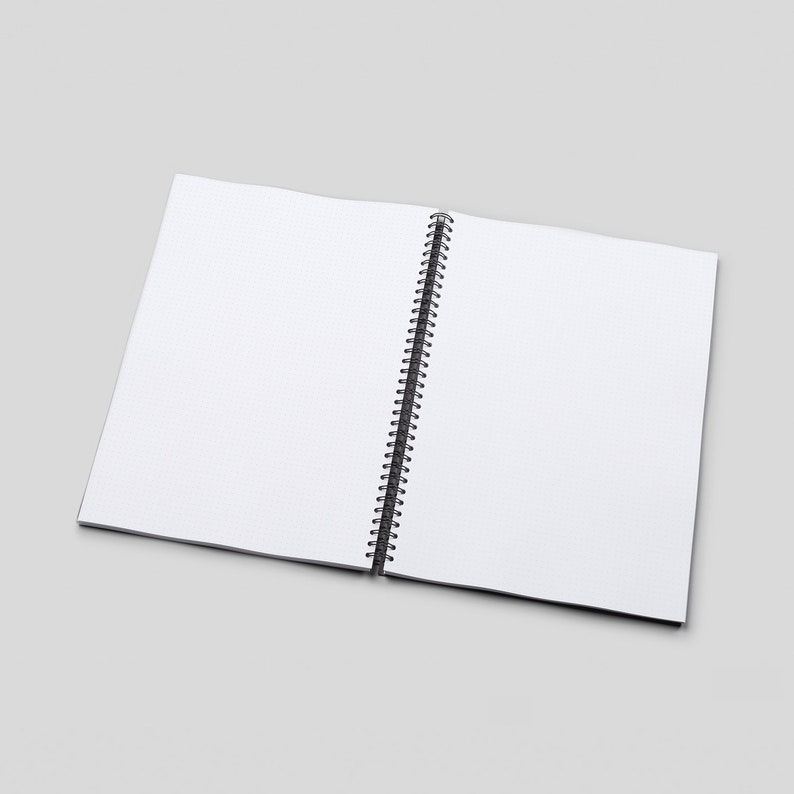 May include: A white spiral bound notebook with a black wire binding. The notebook is open to a blank page.