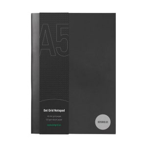 以下が含まれることがあります： 40ページのドットグリッドページと120gsmのブラックペーパーを使用した、ブラックのA5ドットグリッドノートパッド。表紙には「Dot Grid Notepad」と「DOTGRID.CO」の文字が印刷されています。