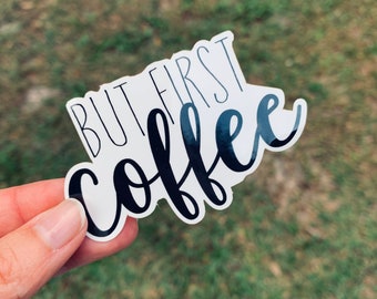 Puede incluir: Pegatina blanca con texto negro que dice "But first, coffee".