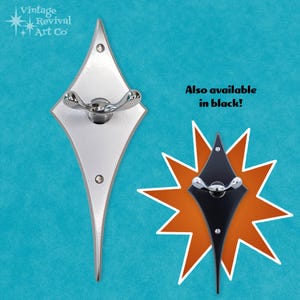 May include: A silver diamond-shaped wall hook with a curved hook arm. Also available in black. "Also available in black!"