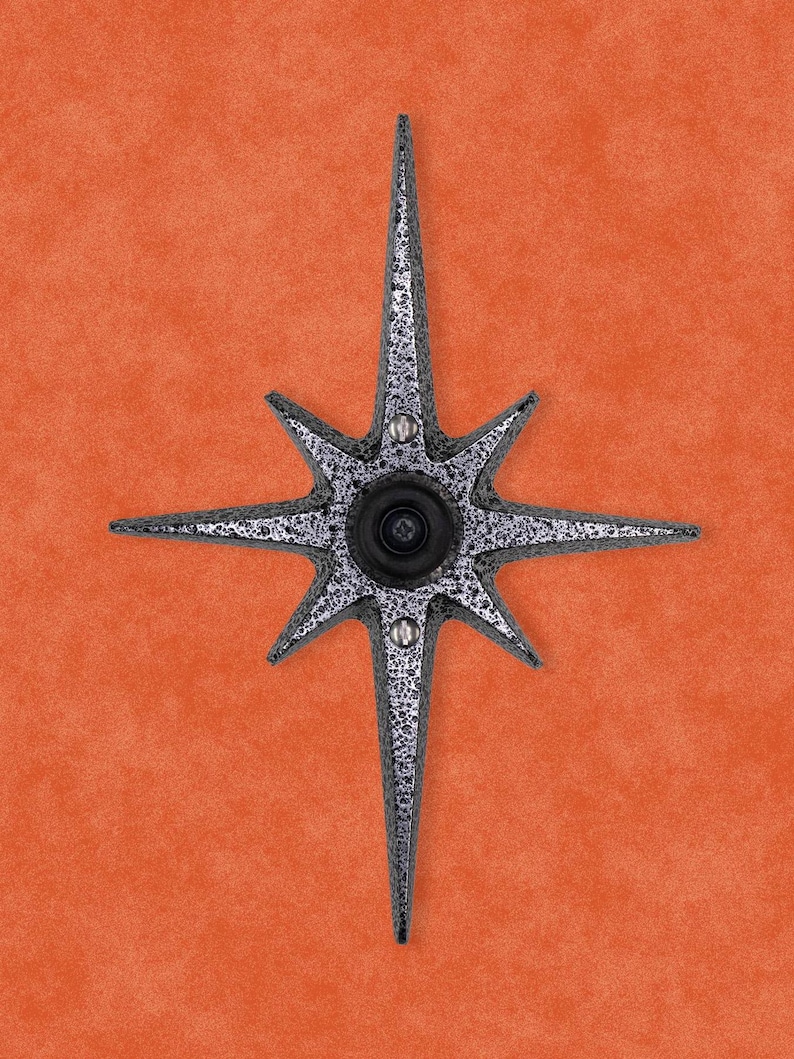 May include: A silver star-shaped door knocker with a round peephole in the center.