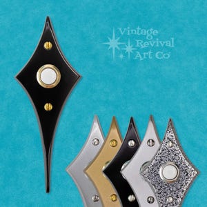 May include: Five diamond-shaped doorbells in different finishes: black, silver, gold, black, and silver with a textured finish. The doorbells have a white button in the center.