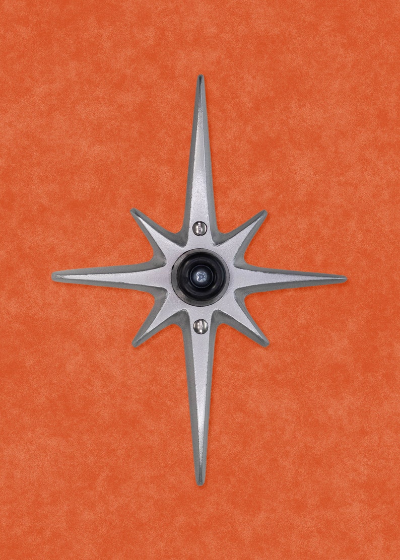 May include: A silver star-shaped door knocker with a black peephole in the center.
