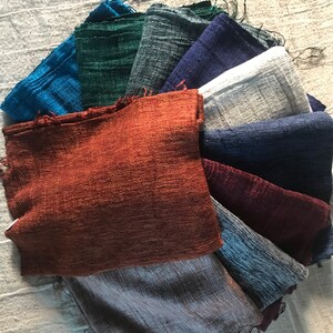 May include: A collection of 10 fabric swatches in various shades of blue, green, brown, gray, and white. The swatches are arranged in a fan shape, with the darkest shade at the bottom and the lightest shade at the top.
