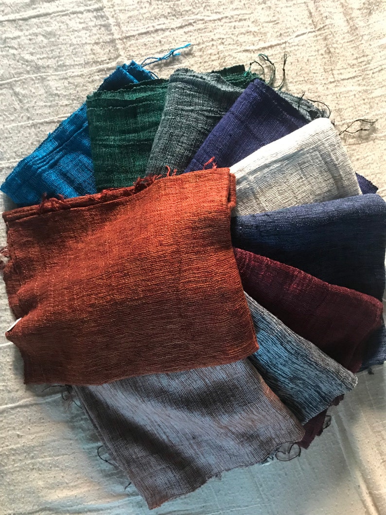 May include: A collection of 10 fabric swatches in various shades of blue, green, brown, gray, and white. The swatches are arranged in a fan shape, with the darkest shade at the bottom and the lightest shade at the top.