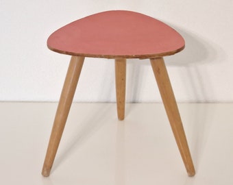 Midcentury tripod plant stand, red colored top, brass frame, three wooden legs, triangular coffee table formica table, 1950s Germany