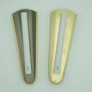 Könnte beinhalten: Zwei Wandleuchten im modernen Design. Eine Leuchte hat eine schwarze Oberfläche, die andere eine goldene. Beide Leuchten haben eine weiße, matte Glasröhre in der Mitte.
