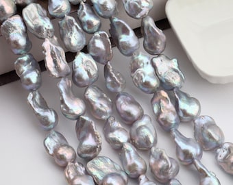 May include: Close-up of strands of iridescent, baroque-shaped pearls. The pearls have a lustrous, silvery-grey colour with hints of blue and green. The irregular shapes of the pearls add to their unique appeal, suggesting they are natural and organic.
