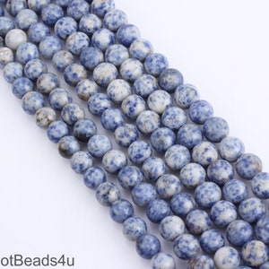 Può includere: Una collana di perline rotonde blu e bianche macchiate. Le perline sono fatte di pietra naturale e hanno un aspetto screziato.