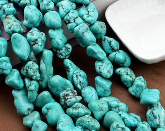 May include: Close-up of a strand of turquoise gemstone beads. The beads are a vibrant turquoise color with dark matrix patterns. The irregular, tumbled shape of the beads adds a natural, organic feel. Ideal for jewelry making.