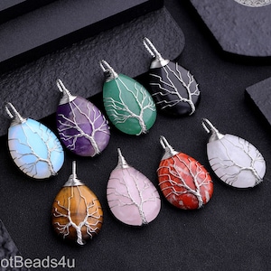 May include: Assortment of 10 wire wrapped tree of life pendants in various colors and stones, including amethyst, green aventurine, black obsidian, rose quartz, tiger's eye, and red jasper.