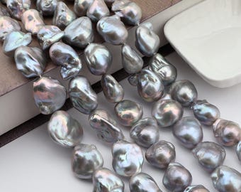 May include: Strands of iridescent, baroque-shaped pearls in shades of grey and silver. The pearls have a lustrous sheen and irregular shapes, suggesting a natural origin. The pearls are strung together, ready for jewellery making.