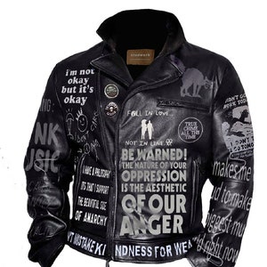 May include: Black leather jacket with various white and gray text and graphics, including "BE WARNED! THE NATURE OF YOUR OPPRESSION IS THE AESTHETIC OF OUR ANGER" and "I'M NOT OKAY BUT IT'S OKAY".