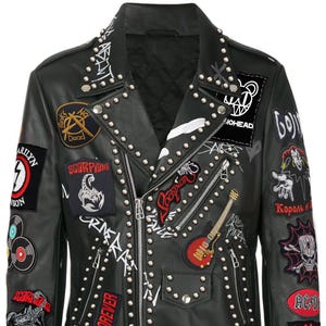 May include: Black leather jacket adorned with patches, studs, and zippers. Patches include band logos, a scorpion, and the text "PUNKERS" and "BIKER FOREVER". The jacket has a classic biker style with a notched collar and a buckled belt at the waist.