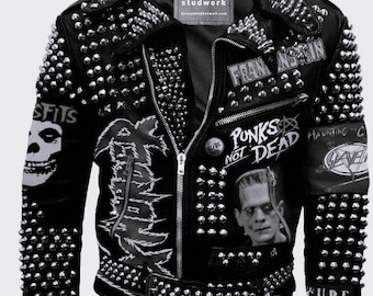 Pode incluir: Jaqueta de couro preta com tachas e patches prateados. Os patches apresentam logotipos de bandas, incluindo Misfits, The Cure, Slayer e "Punks Not Dead".