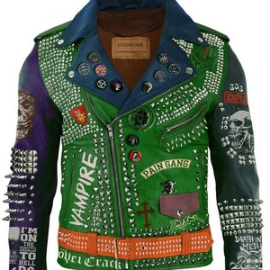 以下が含まれることがあります： 銀色のスタッズとパッチが付いた緑色の革のジャケット。ジャケットはジッパー留め、襟、長袖です。パッチには「ヴァンパイア」、「ペインギャング」、「デスインメタル」、「アイムオンザハイウェイトゥヘルDC」が含まれています。