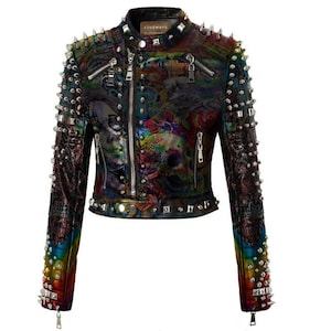 May include: A black leather jacket with a colourful, abstract print and silver studs. The jacket has a zipper closure and two zippered pockets on the front. The jacket also has a studded collar and cuffs.