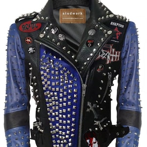 May include: Black leather jacket with blue sleeves and studded accents. The jacket features a zipper closure, multiple patches, and silver studs throughout. Patches include the AC/DC logo and the word "ANAPXIA".