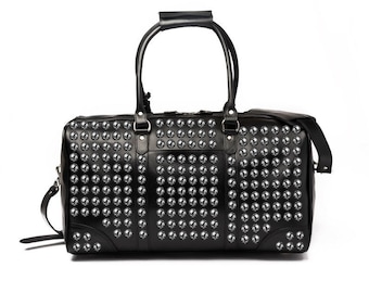 May include: A black leather duffel bag with silver studs covering the entire surface. The bag has a top handle and a shoulder strap.