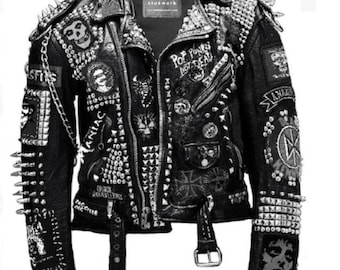 Pode incluir: Uma jaqueta de couro preta com tachas e espinhos prateados. A jaqueta tem vários patches costurados, incluindo um patch de banda que diz "Pop Punks Not Dead".