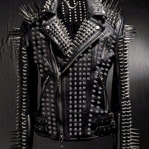 May include: Black leather jacket with silver metal spikes and studs. The jacket features a classic biker style with a notched collar, asymmetrical zipper, and multiple pockets. The shoulders and sleeves are adorned with long, sharp spikes.
