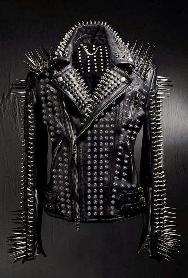 May include: Black leather jacket with silver metal spikes and studs. The jacket features a classic biker style with a notched collar, asymmetrical zipper, and multiple pockets. The shoulders and sleeves are adorned with long, sharp spikes.