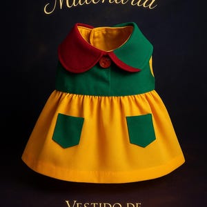 May include: A dog dress in yellow, green, and red, with the text "La Perra Millonaria" and "Vestido de La Chilindrina". The dress has a green collar with a red trim, a yellow skirt, and green pockets.