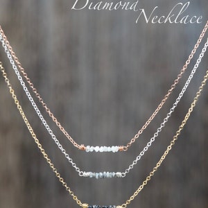 Puede incluir: Tres delicados collares con una fila de peque&ntilde;os diamantes en bruto. El collar superior tiene diamantes blancos, el collar del medio tiene diamantes grises y el collar inferior tiene diamantes negros.