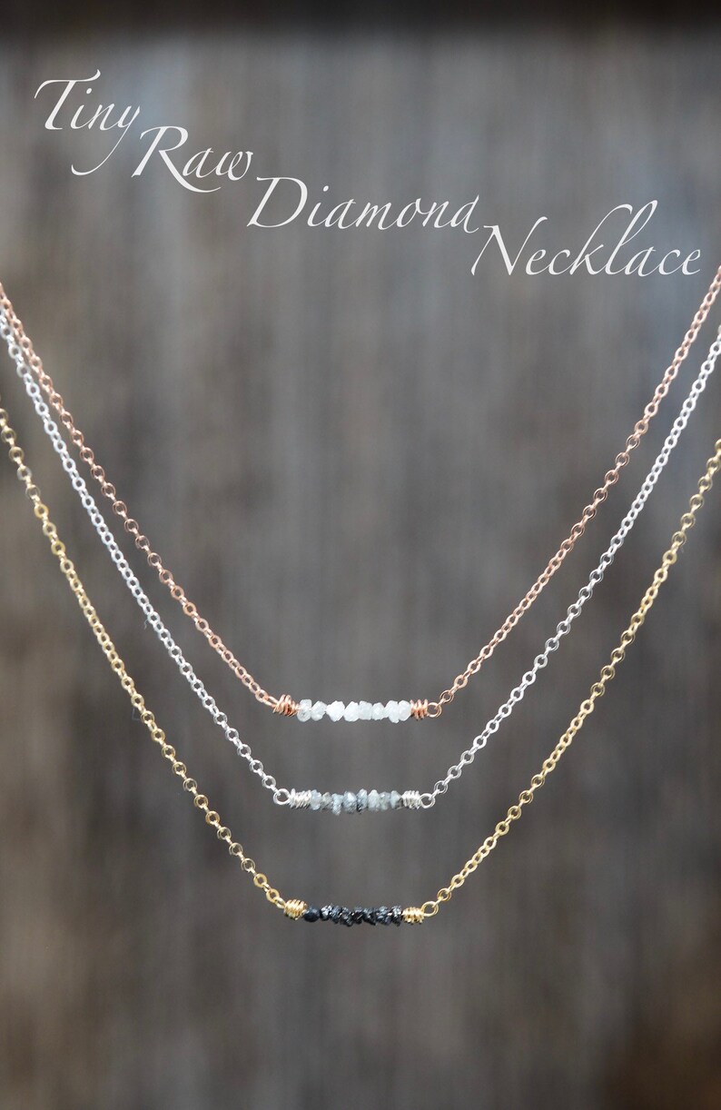 Puede incluir: Tres delicados collares con una fila de peque&ntilde;os diamantes en bruto. El collar superior tiene diamantes blancos, el collar del medio tiene diamantes grises y el collar inferior tiene diamantes negros.