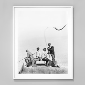 Puede incluir: Impresión en blanco y negro enmarcada de cinco personas pescando en una estructura de madera. Una gaviota vuela por encima. Las personas visten ropa informal, con cañas de pescar en la mano. La imagen tiene un aire vintage y nostálgico.