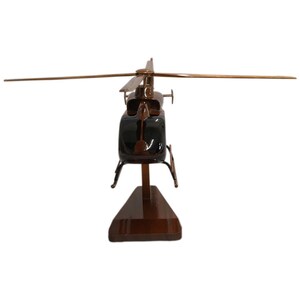 May include: A wooden model of a brown helicopter with black accents. The helicopter is on a wooden stand.
