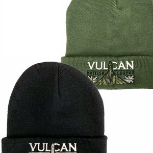 以下が含まれることがあります： 「Vulcan British Legend」という文字と飛行機の刺繍が施されたニット帽が2つ。1つは黒、もう1つは緑です。