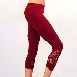 May include: Burgundy leggings with lace detailing at the bottom of the legs.