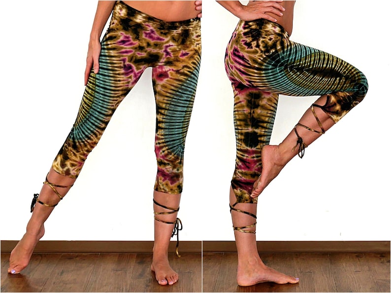 Może przedstawiać: Legginsy tie-dye w brązowym, zielonym i fioletowym wzorze. Legginsy mają sznurowane detale przy kostkach.