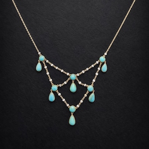 May include: A gold-toned necklace with a delicate chain design. The necklace features turquoise teardrop-shaped pendants and small white gemstones. The necklace is displayed against a black background.
