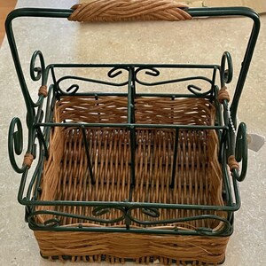 Peut inclure: Un porte-bouteilles en fil métallique vert avec un panier en osier tissé. Le porte-bouteilles a une poignée et des volutes décoratives.