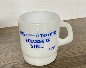 May include: White ceramic mug with a blue key graphic and the text "The key to our success is you... ETIB".