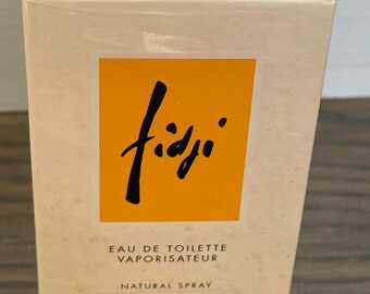 May include: A rectangular box of Guy Laroche Fiji Eau de Toilette. The box is off-white with a bright orange label featuring the word "fidji" in black script. The box contains 1.7 fl oz (50 ml) of natural spray.