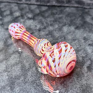 Thick triple layered glass pocket pipe in juicy garnet reds with ghostly purple wrap and rake exterior